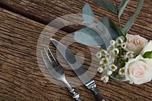 Fork and butter knife with rose flower n wooden table