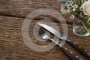 Fork and butter knife with rose flower n wooden table