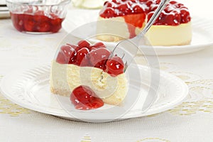 Fork cutting cherry cheesecake