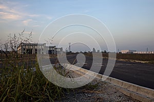 Fork in an empty road in an industrial complex at sunset