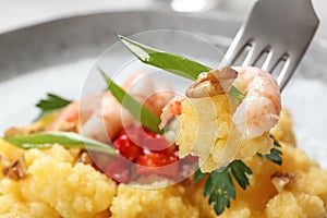 Fork with fresh tasty shrimp and grits closeup