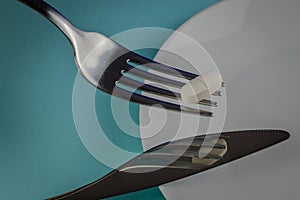 fork holding up a medicine pill on an blue background - concept for eating problems, medicine abuse, chemical feeding