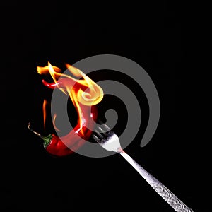 Fork impale to red hot chili on black
