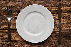 Fork and knife lying near empty white plate