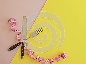 Fork knife measuring tape balance   on colored background