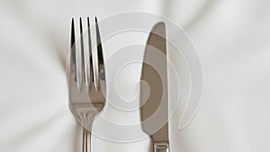 The fork has four tines and the knife has a smooth slightly curved blade