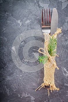 Fork with a knife in the sacking on a gray background