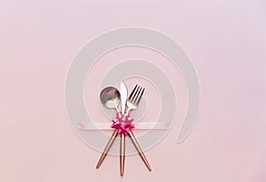 Fork, knife, spoon, silverware with on pink background for catering,