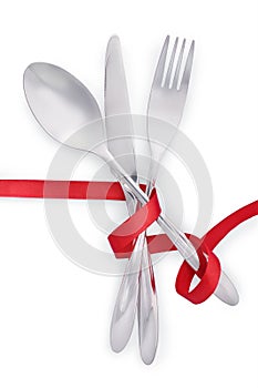 Fork, knife and spoon tied with red ribbon isolated