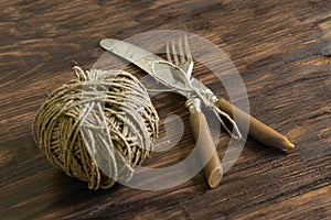 Fork, knife and thread on a wooden table