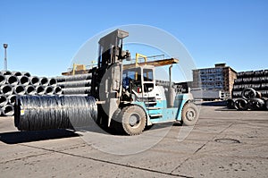 Fork lift in a steel mill with metal rolls