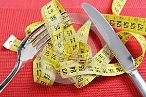 Fork in measure tape in diet and overweight concept