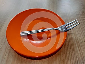 a fork on an orange cake plate.