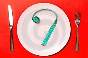 Fork and plate with measuring tape on color background. Diet concept