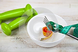 Fork, plate, measuring tape and dumbbells