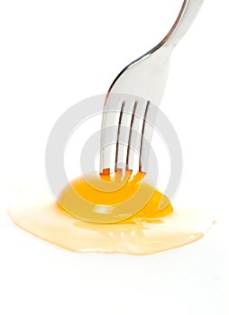 The fork pricking the raw egg photo