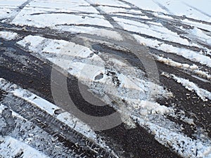 A fork or siding from a roundabout. Snowdrifts on the side of the road. Bad weather. Snow on asphalt. Difficult driving