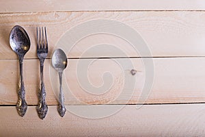 Fork, spoon, knife on the wooden table background with copy place. Concept kitchen and restaurant service. Top view.