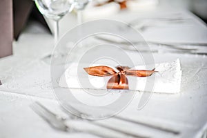 Fork and spoon table decoration with ribbon over a white restaurant napkin