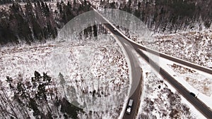 A fork on a suburban highway with driving cars in winter, aerial view.