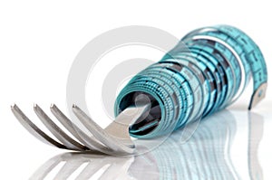 Fork surrounded by a seamstress meter on a white background