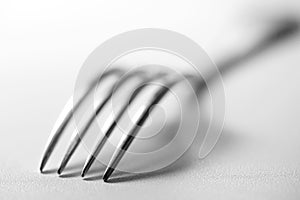 Fork on a table. Tableware on white to won. Still life.