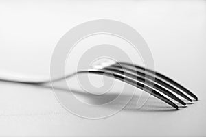 Fork on a table. Tableware on white to won. Still life.