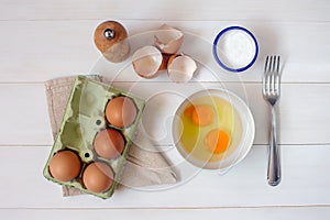 Fork for whipping eggs and raw eggs in a bowl