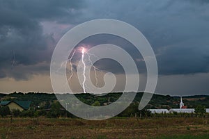 Forked lightning bolt strikes in the rural landscape of Transylvania