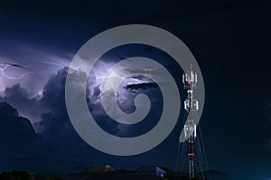 Forked lightning over the cell phone antenna tower in the night sky
