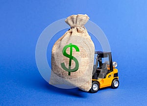 Forklift carries a huge money bag with the symbol of US dollar. Budget and taxpayer funds. Investment and capital migration