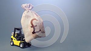 Forklift carrying a british pound sterling money bag. Strongest financial assistance, business support. Stimulating economy.