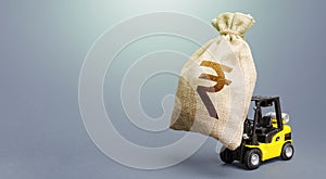 Forklift carrying a indian rupee money bag. Strongest financial assistance, business support. Borrowing on capital market.