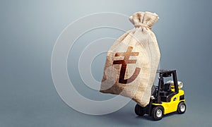 Forklift carrying a turkish lira money bag. Strongest financial assistance, business support. Stimulating economy. Anti-crisis