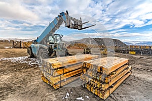 Forklift on a construction site, preparing to raise construction parts