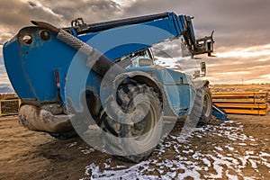 Forklift on a construction site, preparing to raise construction parts