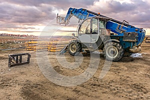 Forklift on a construction site, preparing to raise construction parts