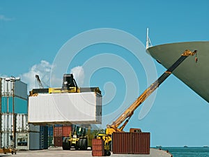 Forklift, crane in busy container port.