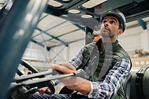 Forklift driver carefully moving stock around a warehouse floor