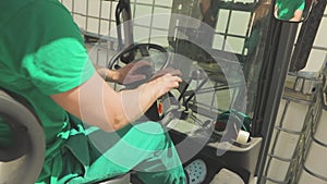 The forklift driver moves the levers. A worker operates a forklift. Forklift control process