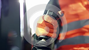 Forklift driver in protective vest driving forklift at warehouse of freight forwarding company. Man on the forklift