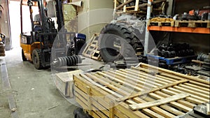 Forklift driver in protective vest driving forklift at warehouse of freight forwarding company. Man on the forklift