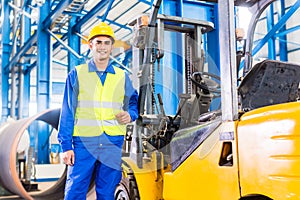 Forklift driver standing in manufacturing plant