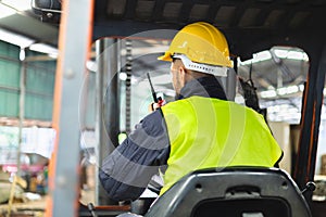 Forklift driver talking on radio for professional cargo shipping communication