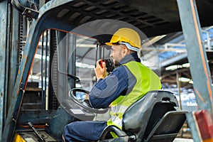 Forklift driver talking on radio for professional cargo shipping communication