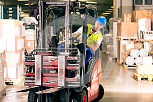 Forklift driver at warehouse of forwarding