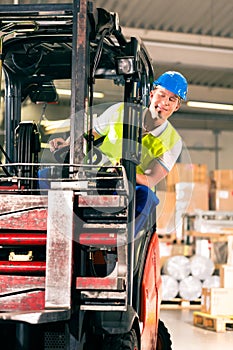 Forklift driver at warehouse of forwarding