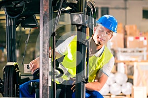 Forklift driver at warehouse of forwarding