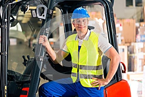 Forklift driver at warehouse of forwarding