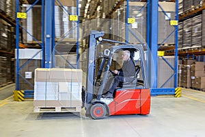 Forklift driving alongside a storage rack.